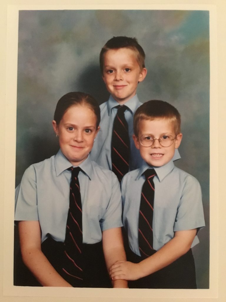 A photo of 3 me and my siblings in school uniforms